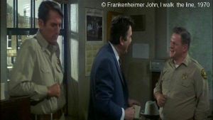  I walk  the line  de Frankenheimer John.   Photogramme 38. Au commissariat, l’agent Bascomb entouré du shérif et de son adjoint.