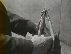 Photogramme - Sac 1 : Un Condamné à Mort s'est échappé, Plan 15. Avec un bout de ficelle et un mouchoir, Fontaine confectionne un sac.