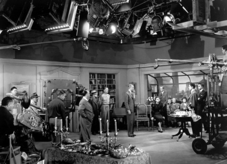 La Corde, Alfred Hitchcock en studio dirigeant les acteurs. Au premier plan le coffre de la monstruosité recouvert d'une nappe.