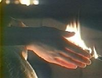 Photogramme - main : Miroir (Le), Plans 28 et 150. La main rougie par une flamme de feu.