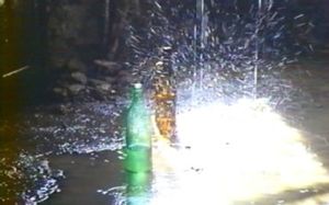 Photogramme Bouteille 3 : Nostalghia, Plan 54. Les trois bouteilles posées au sol, sous la pluie.