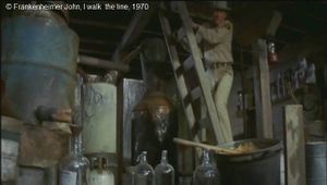  I walk  the line  de Frankenheimer John.   Photogramme 40 Le shérif découvre la trappe, l’ouvre et descend l’échelle qui mène à la distillerie clandestine.