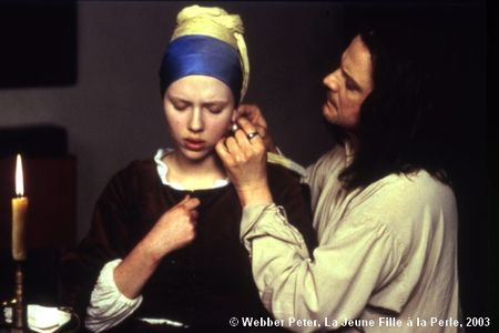 La Jeune Fille à la Perle. Vermeer qui fixe la boucle d'oreille sur l'oreille de Griet. Un acte lourd de conséquence  : c'est la relation entre les deux personnages qui sera fixée, sans parler de la perforation du trou d'accrochage.