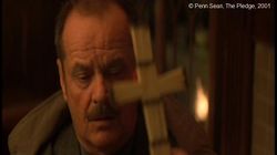   The Pledge  de Sean Penn. Photogramme - 9.  0h 18’ 06’’. En retrouvant ses esprits, la mère de la victime présente devant Jerry, une croix en allumettes que sa fille avait fabriquée,  et elle lui fait promettre, sur la croix, de retrouver l’assassin cruel de sa petite fille.