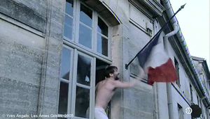   Les Âmes Grises  d'Yves Angelo.   Photogramme 11.  L'Instituteur, presque nu, sort de la fenêtre pour saisir le drapeau tricolore.