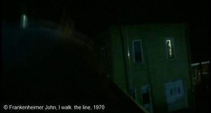   I walk  the line  de Frankenheimer John.   Photogramme 55. Dans le prolongement de la voiture, au fond, une maison avec une silhouette qui se déplace devant une fenêtre encore éclairée.