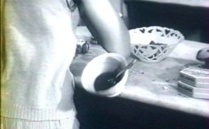 Photogramme - café 2: Mouchette. Une habitante du village invite Mouchette à prendre un bol de café, plus par curiosité que par compassion.
