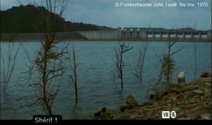 Photogramme – Ligne 9,  I walk  the line  de Frankenheimer John.  Premier plan du film.   Un large fleuve qui coupe en diagonale l’image. Au fond, un barrage hydroélectrique.